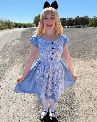 Coco in a blue costume dress with a bow